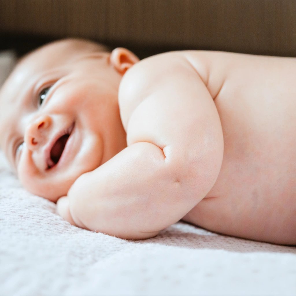 Bébé allongé sur le ventre avec une fossette visible juste au-dessus des fesses
