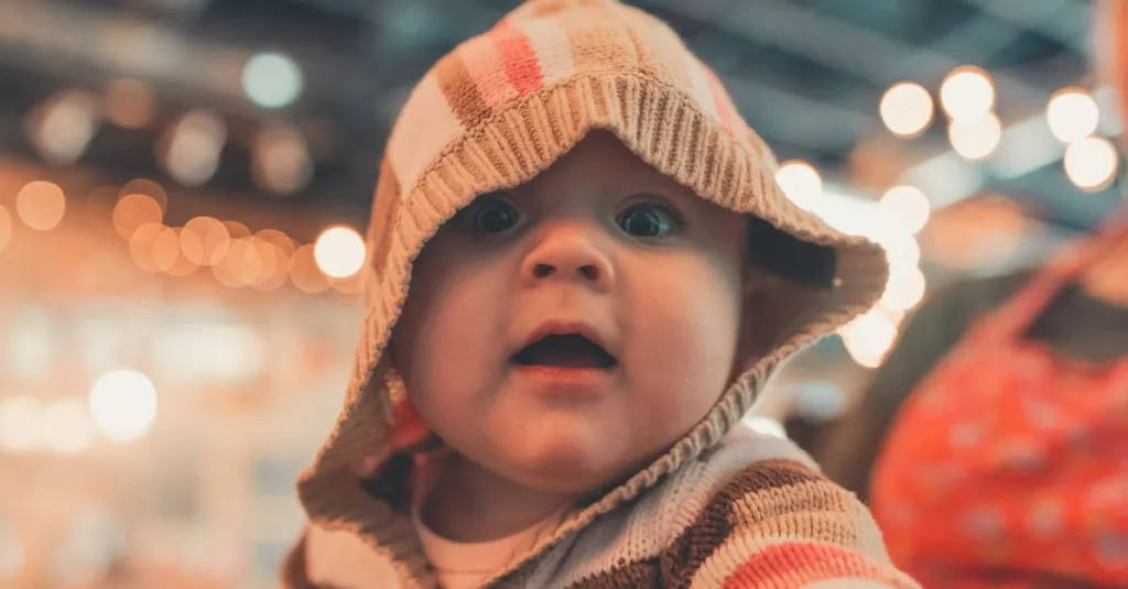 un bébé qui tend la main pour saisir un objet, symbolisant la curiosité et le développement des compétences motrices chez les tout-petits.